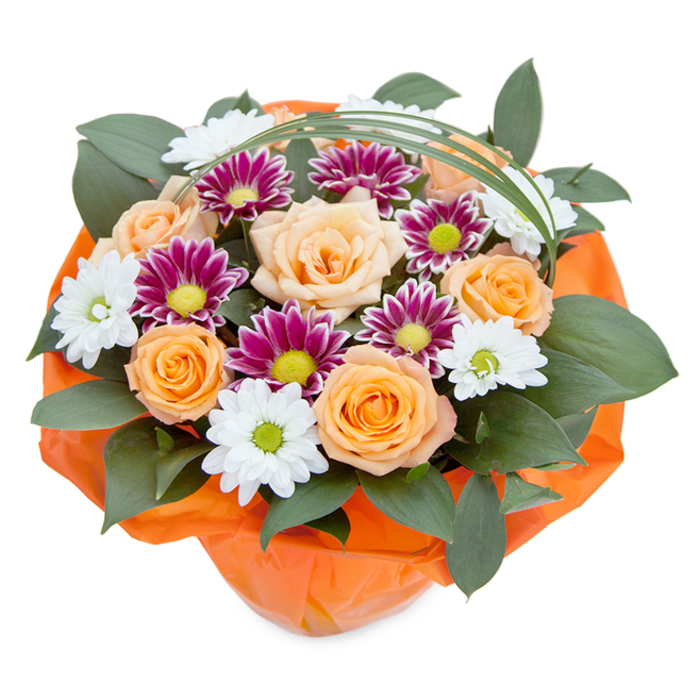 In this elegant and lush floral composition, arranged by Vauxhall flower specialists and viewed from a gently elevated perspective, the interplay of warm, welcoming tones creates an atmosphere of celebration. The bouquet's centre is crowned with blooming roses that span a gradient from creamy peach to bright, sunlit orange, their delicately spiralled petals unfurling with classic grace. White daisy-like chrysanthemums, their slender petals radiating from soft green centres, mingle with deep magenta and purple blooms, each punctuated by a lively lime disc-together, these flowers conjure images of local spring meadows and the vibrant diversity of Vauxhall's friendly markets. The layering of dark, glossy foliage, perhaps ruscus or similar broadleaf greens, supports and frames the vivid blooms, injecting a sense of abundant greenery and fresh garden vitality. Overarching the arrangement, a single arc of slender bright green grass imparts a modern, airy feel. The whole bouquet is hand-gathered and wrapped at its base in cheerful, crinkly orange paper that echoes the warmth of the roses, forming a striking and cohesive visual statement. This arrangement, perfect for same-day gifting in Vauxhall-be it for birthdays, joyful reunions, or heartfelt gestures-invites the recipient to experience the textures, scents, and thoughtful craft that define local floristry.